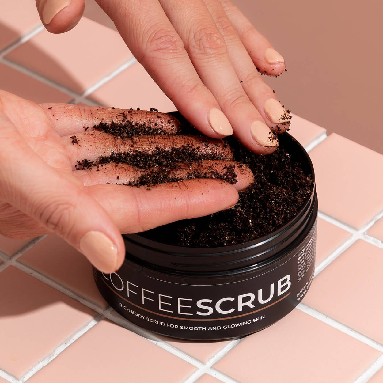 A girl is applying a Byrokko Coffee body scrub on her hands.