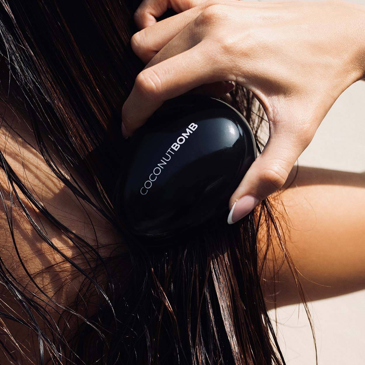 Woman brushing her hair with Byrokko hairbrush.