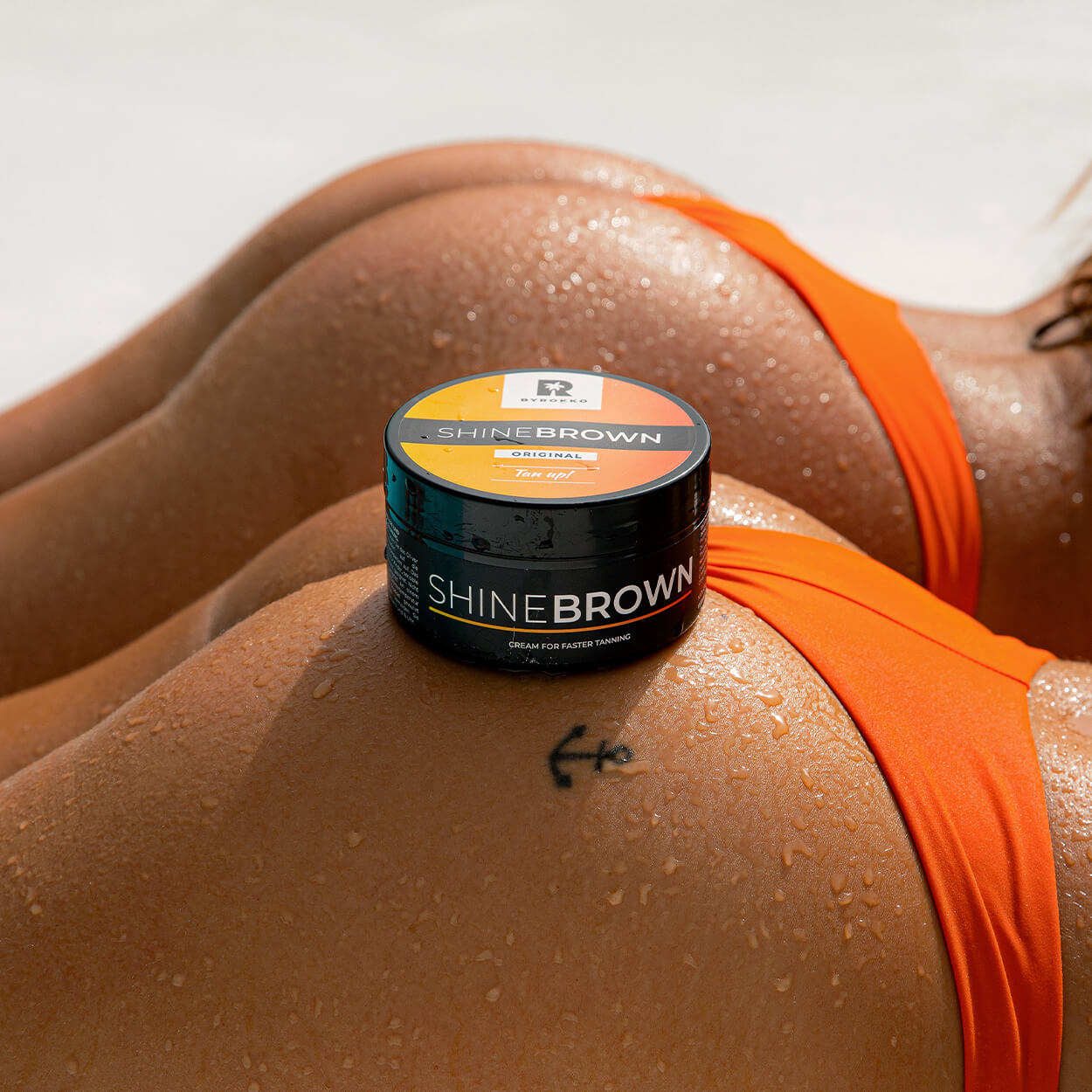 Shine Brown Tan up! tan cream on the bottom of a tanned girl in an orange bikini.