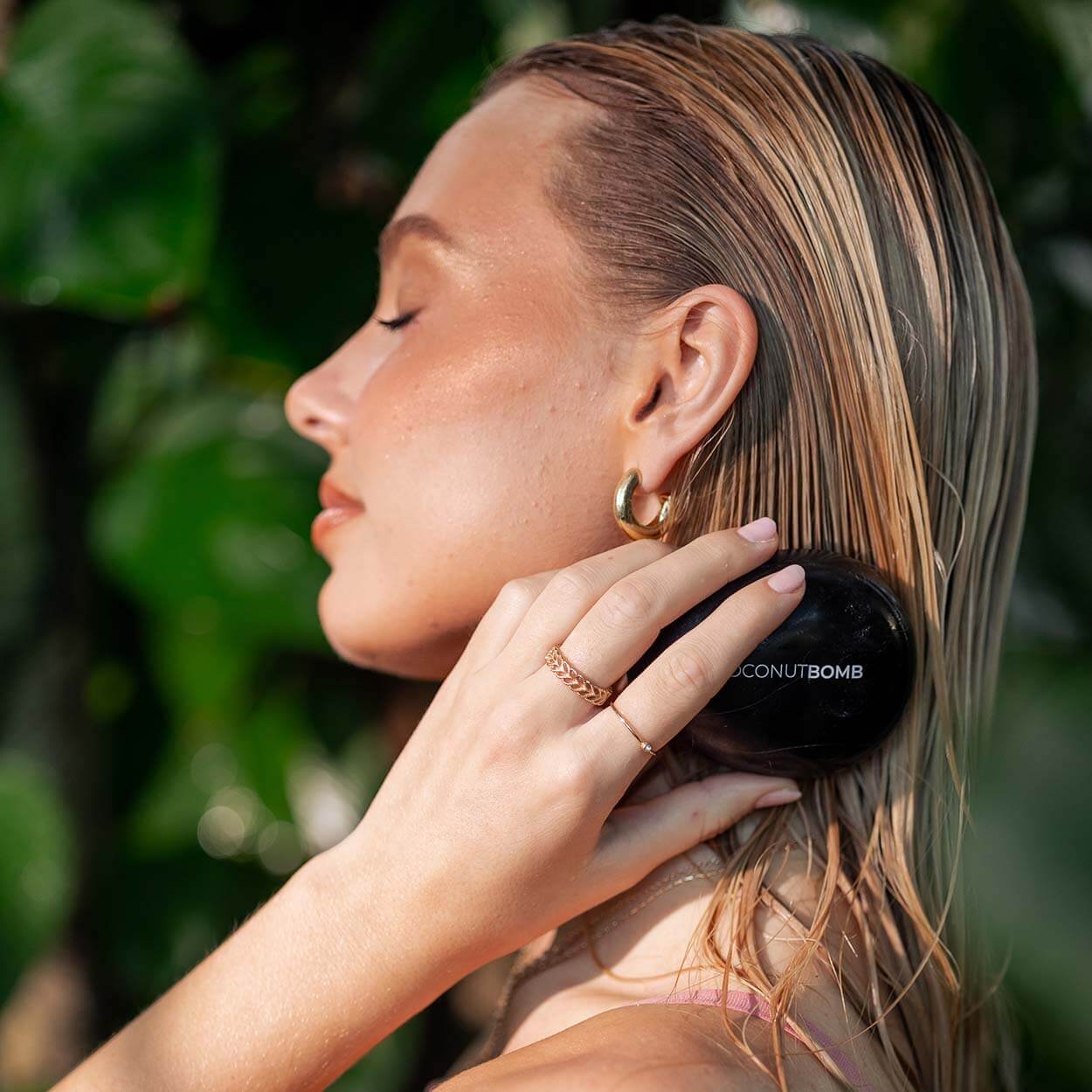 Blonde woman brushing her hair with Byrokko hairbrush.