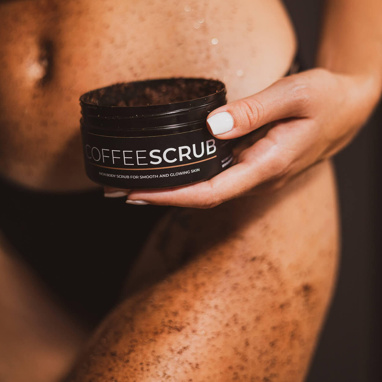 A girl is applying a Byrokko Coffee scrub on her body.